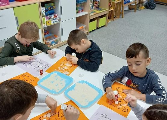 Dzieci podczas wyklejania misia.