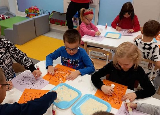 Dzieci podczas wyklejania misia.