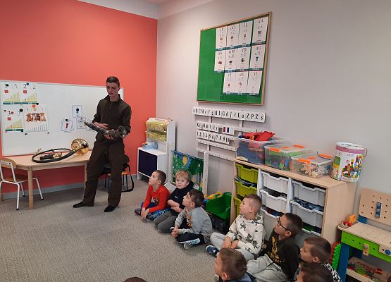 Sygnalista myśliwski pokazuje instrument grupie dzieci.