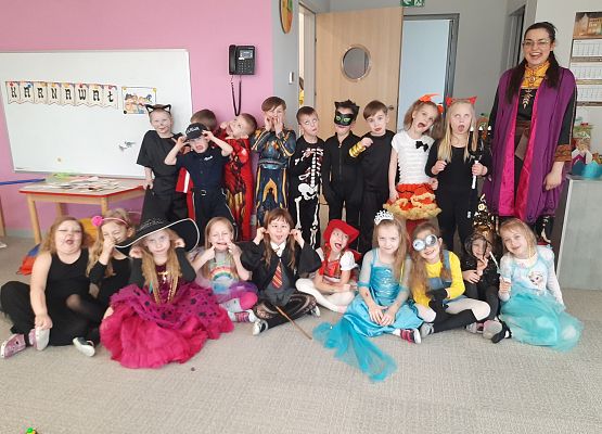 Grupa dzieci z wychowawcą ubrana w stroje balowe.