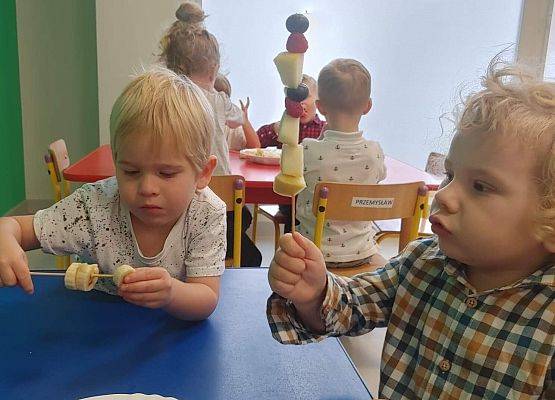 Dzieci robią szaszłyki z owoców.