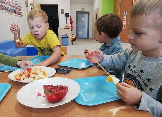 Dzieci robią owocowe szaszłyki.