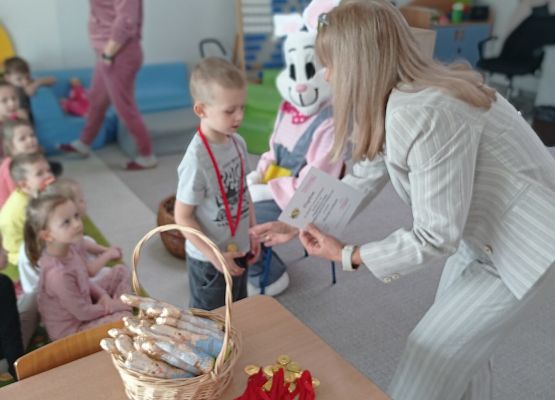Zajączek przekazuje upominki dla uczestników konkursu.
